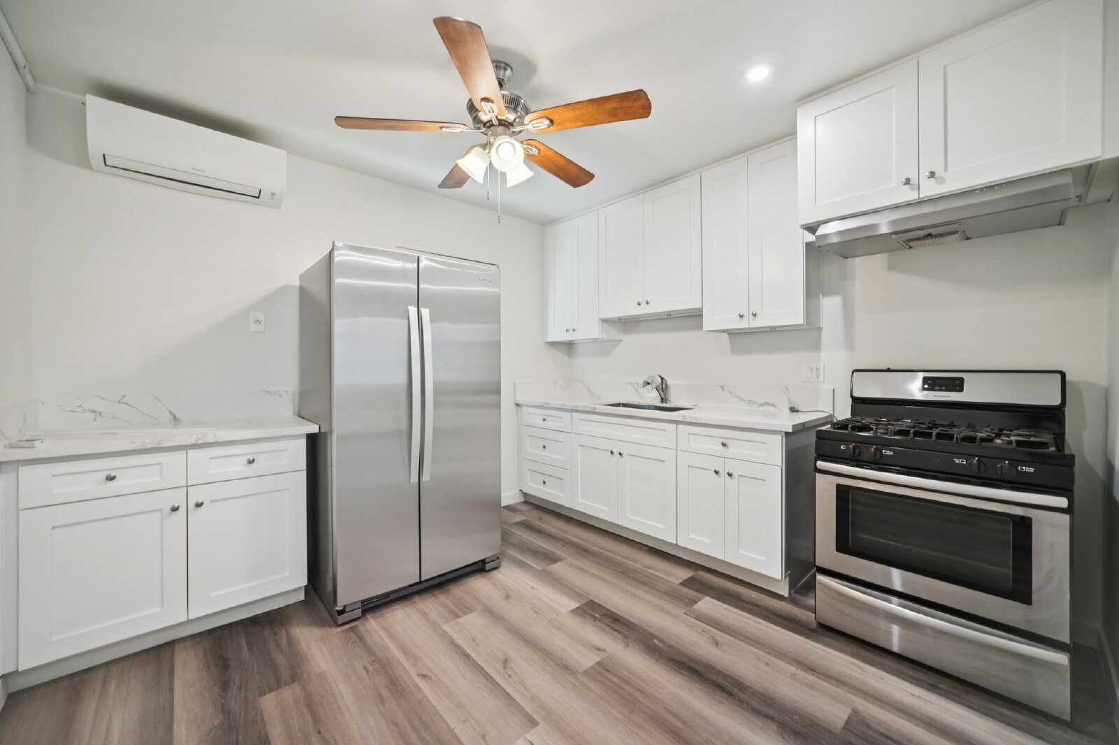 Renovated kitchen with stainless steel appliances and white shaker cabinets